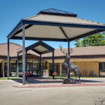 The image shows the entrance of a building with a canopy and a deer statue.