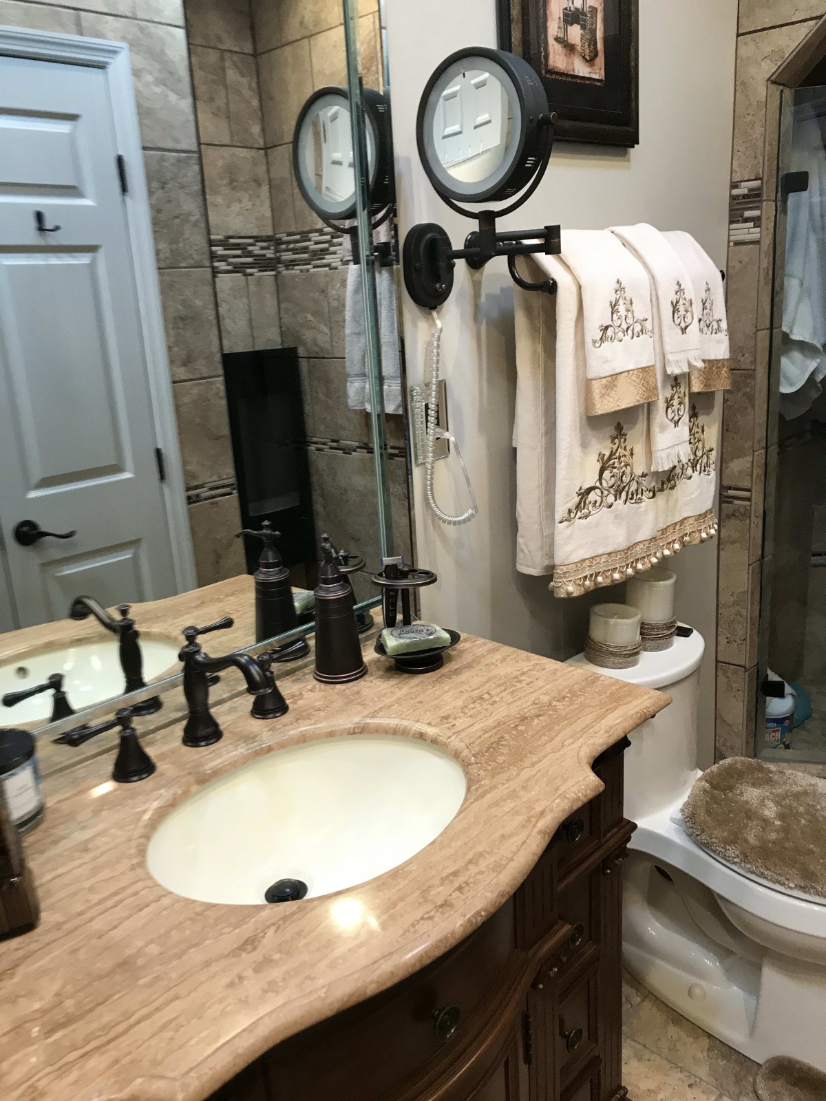 A neatly organized bathroom with a sink, mirror, and hanging towels.