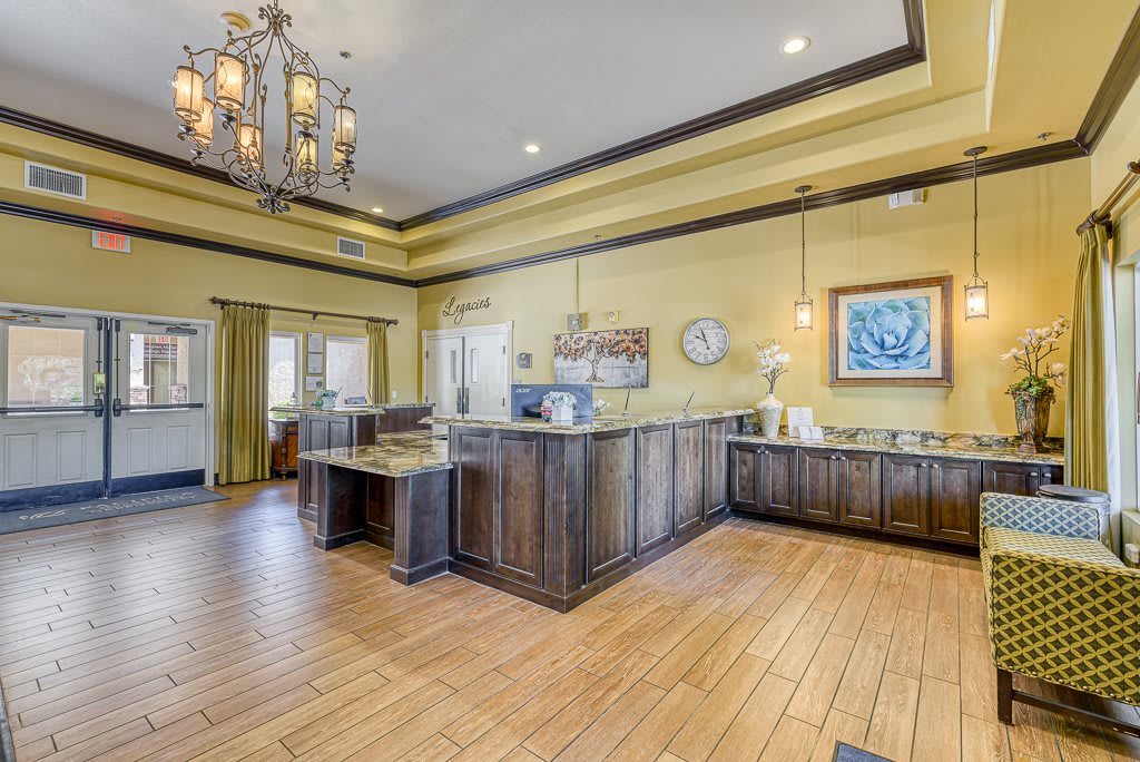 A well-lit reception area featuring wood flooring and elegant furniture.