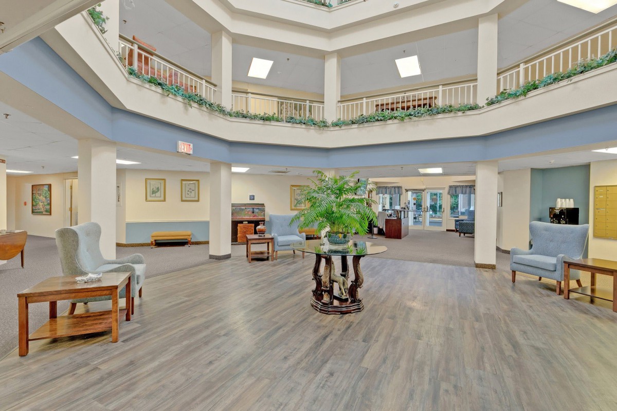 A spacious atrium with elegant furnishings and a large central plant display.