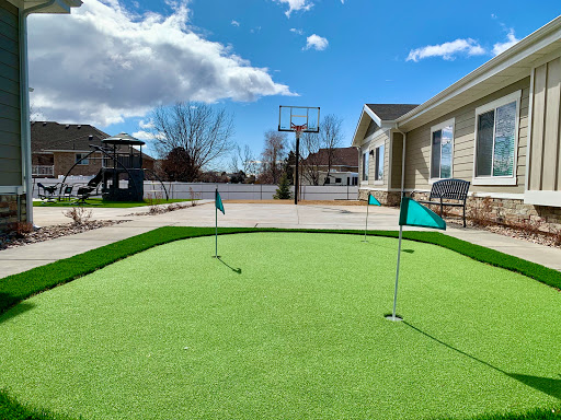 A beautifully designed backyard putting green, perfect for practicing golf skills on a sunny day.