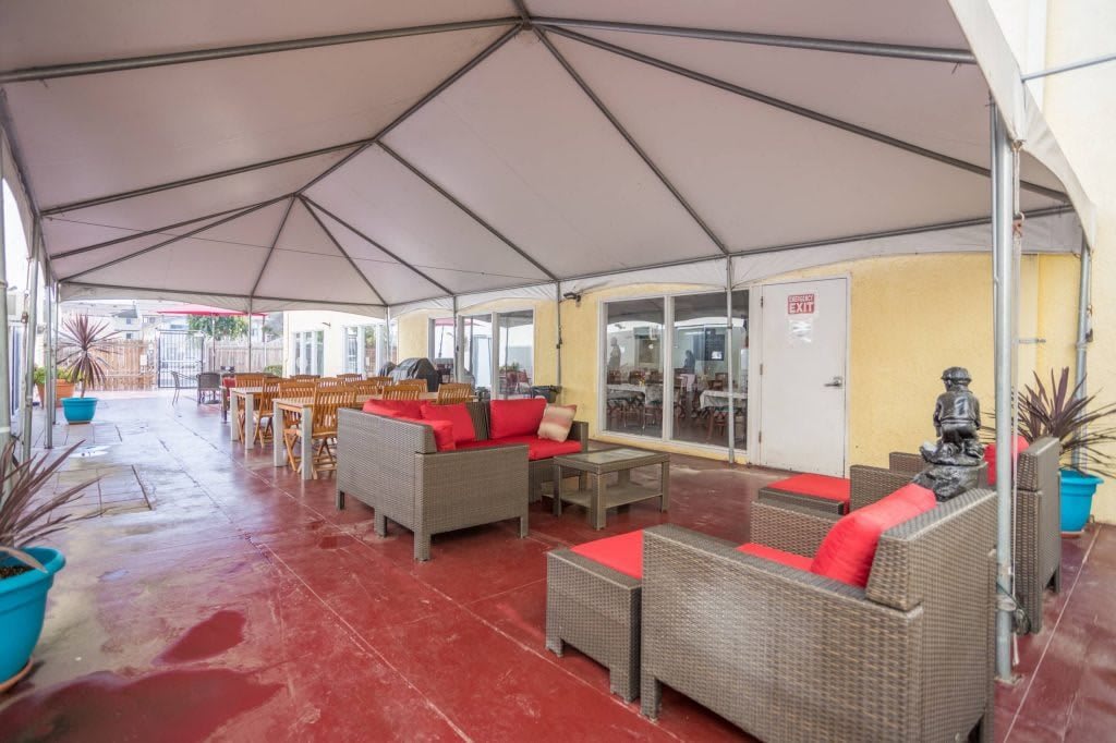 An outdoor patio with comfortable seating under a canopy.