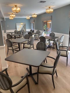 An empty dining room with neatly arranged tables and chairs.