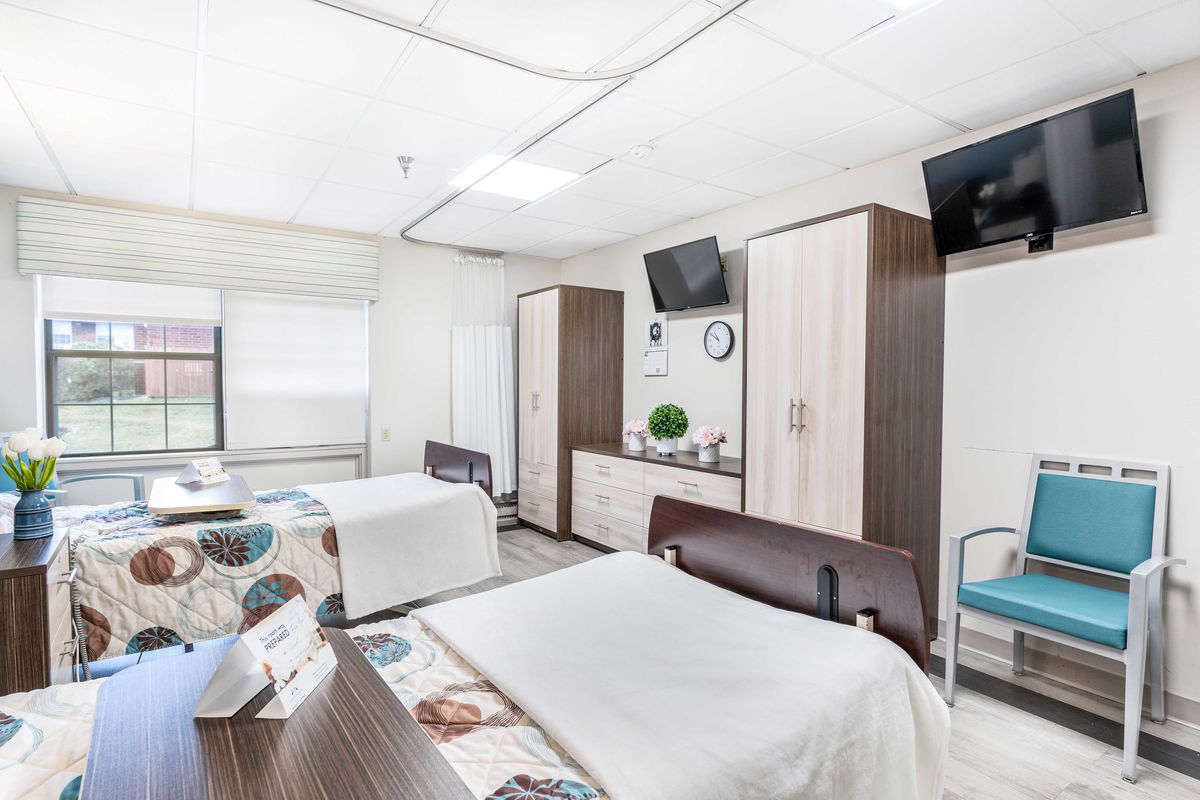 A modern and clean hospital room with two beds and medical equipment.