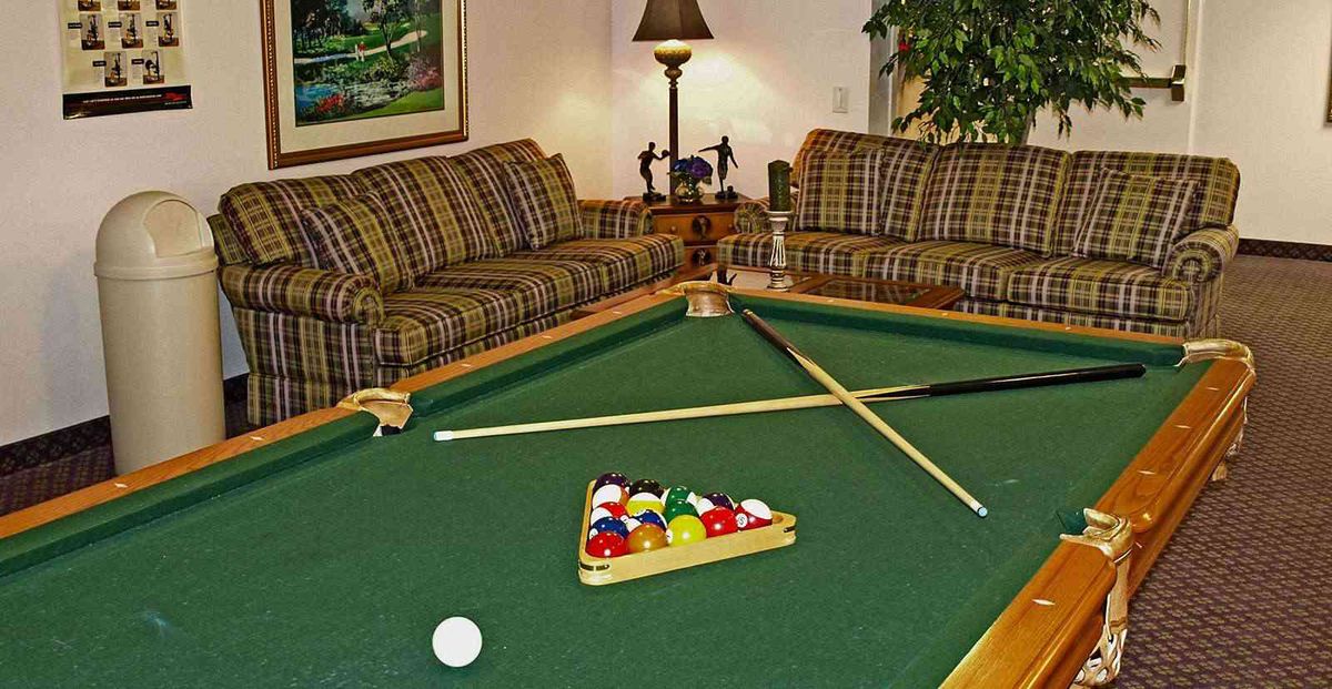 A cozy living room with a pool table ready for a game of billiards.