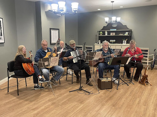 A lively group of musicians enjoying a collaborative music session indoors.