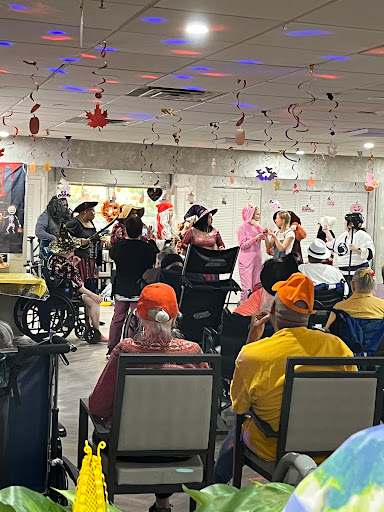 A lively performance entertaining an audience of seniors, decorated for a festive occasion.
