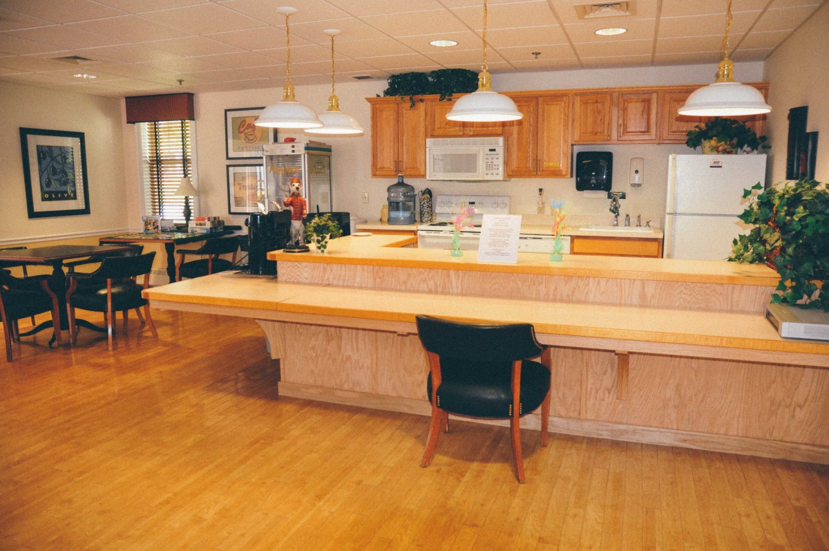 A modern kitchen interior with wooden cabinets and a spacious dining area.