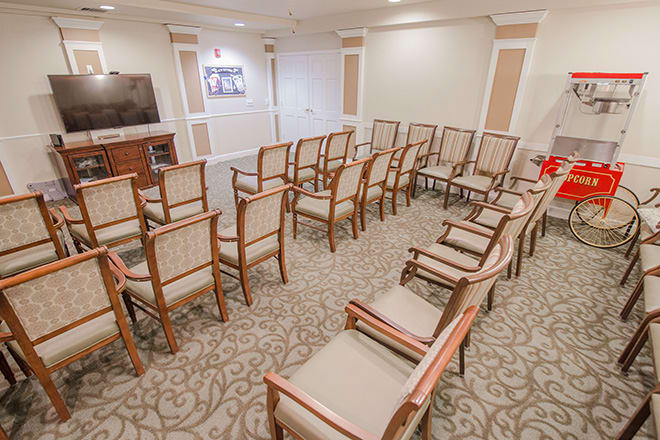An empty conference room with rows of chairs arranged in a semi-circular pattern.
