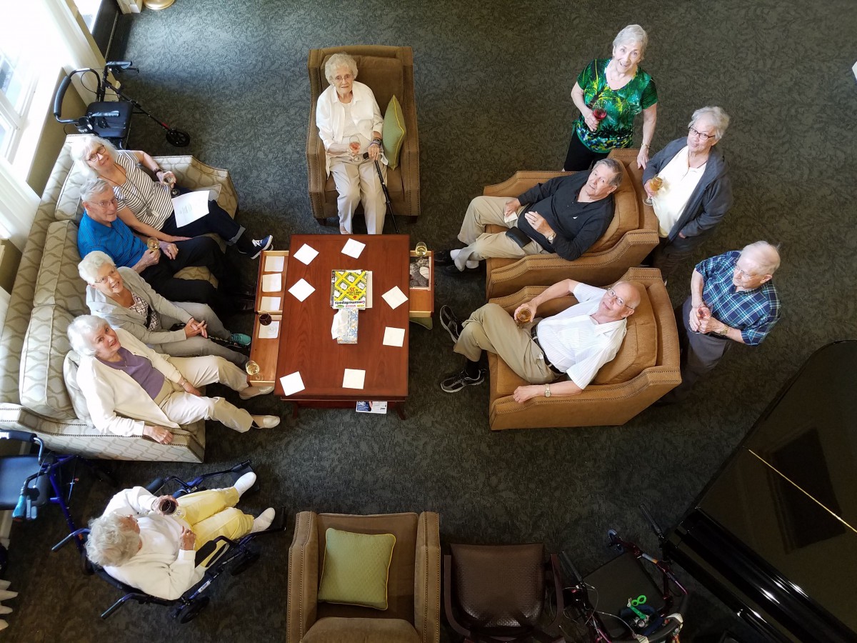 A group of seniors gathered in a seating area, viewed from above.