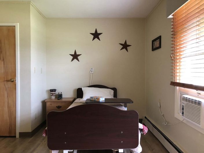 A minimalist hospital room with a single bed and decorative stars on the wall.
