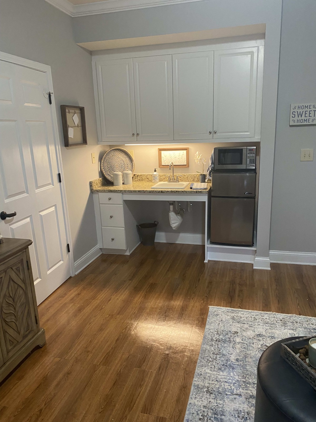 A cozy kitchen area with white cabinets and modern appliances.