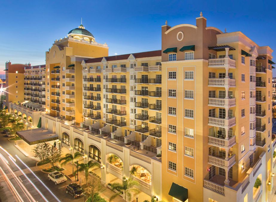 A luxurious hotel building illuminated at dusk with multiple balconies and architectural details.