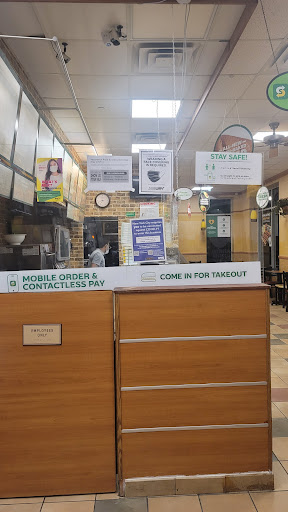 A view of the service counter at a restaurant, featuring menus and informational signage.