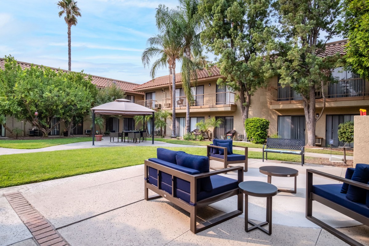 A tranquil courtyard with patio furniture and lush greenery.