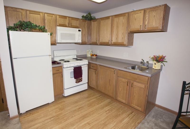 A modern kitchen with wooden cabinets and standard appliances.