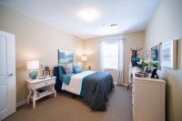 A cozy bedroom with a neatly made bed and elegant decor.