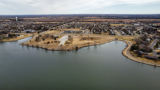 Aerial view of a tranquil lake surrounded by suburban developments and natural landscapes.