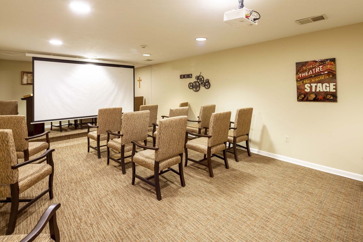 A small conference room with chairs arranged facing a projector screen.