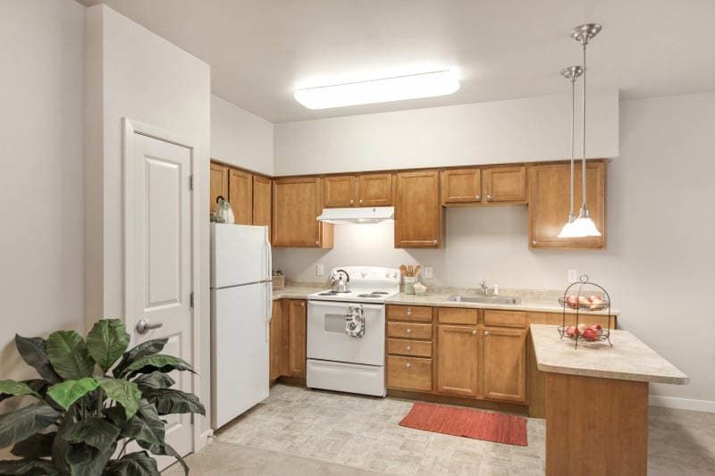 A cozy kitchen with wooden cabinets, a white refrigerator, and an oven.