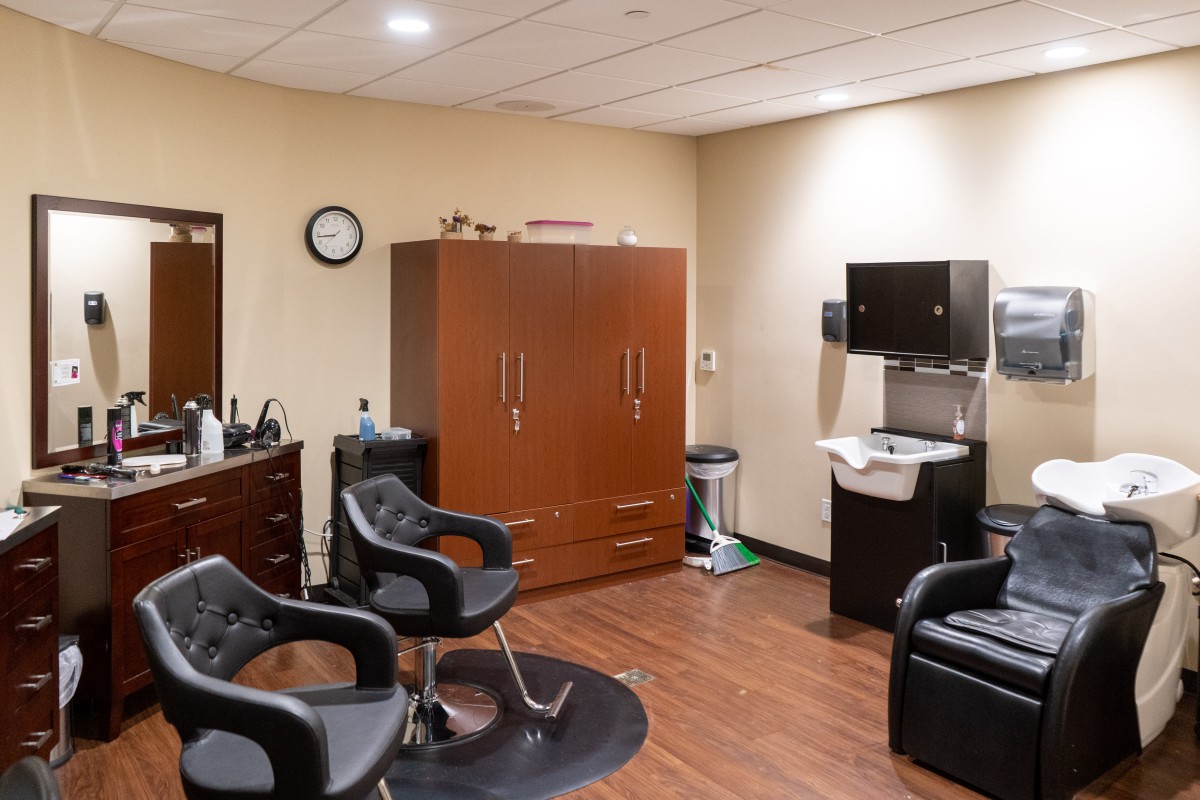 An interior view of a salon with chairs, mirrors, and cabinets.
