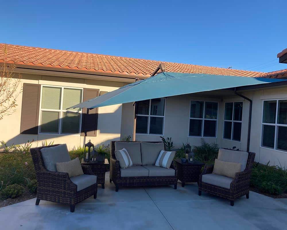 Cozy outdoor patio area with comfortable seating and an umbrella.