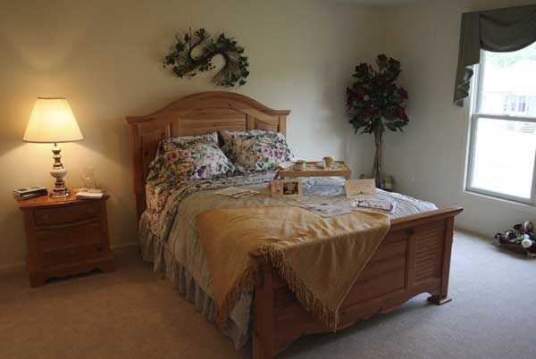 A cozy bedroom with a neatly made bed and warm lighting.