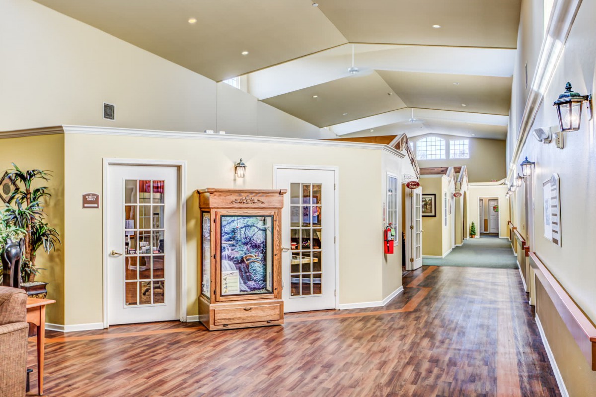 A spacious hallway with wooden flooring and multiple doors leading to adjacent rooms.