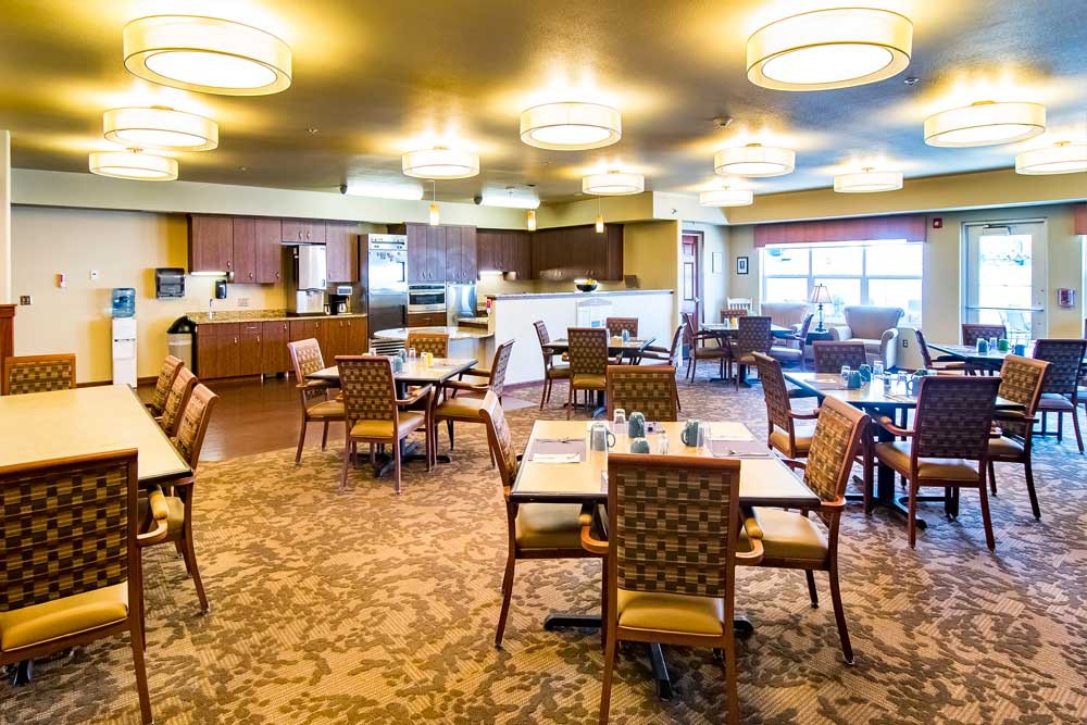 A spacious dining area with modern lighting and neatly arranged tables and chairs.