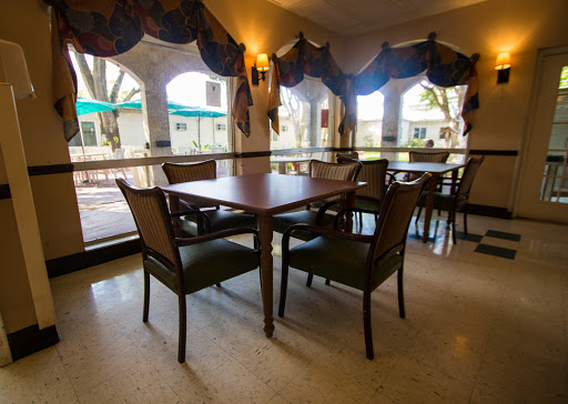 A cozy dining area featuring a wooden table and chairs with a view through the windows.
