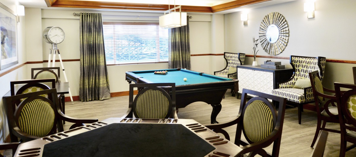 A cozy game room featuring a billiard table and elegant seating.