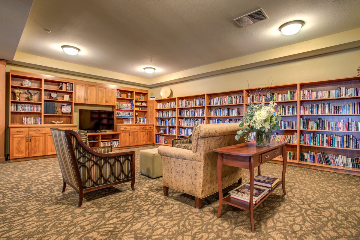 A cozy library with shelves filled with books and comfortable seating.