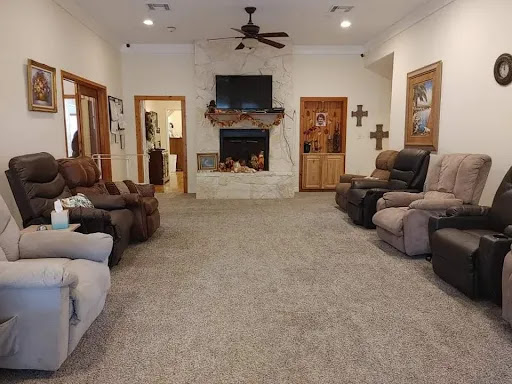 A cozy living room featuring comfortable recliners, a fireplace, and a TV.