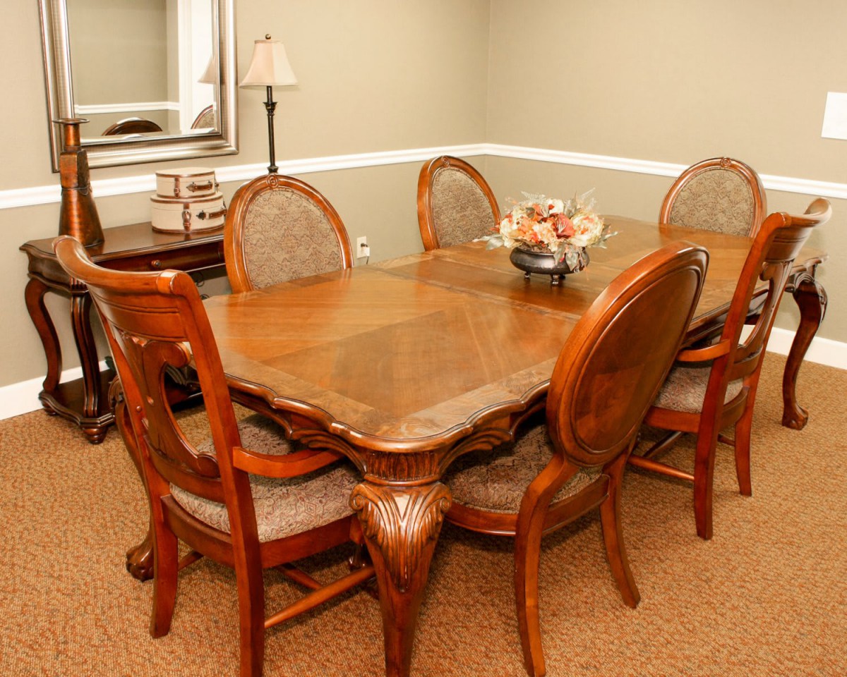 A dining room with a wooden table and chairs, featuring elegant decor.