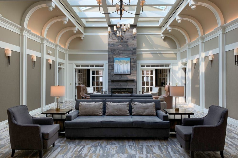 A modern living room with a skylight, featuring a cozy sofa and a central fireplace.