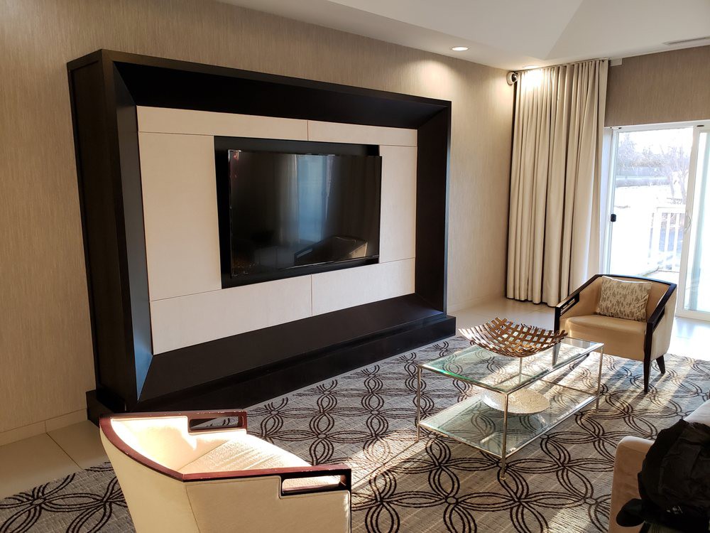 A modern living room with sleek furniture and a large TV setup.