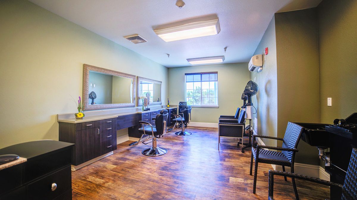 A modern hair salon with stylish chairs and large mirrors, featuring a bright and clean interior with wooden floors.