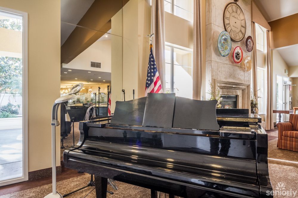 A grand piano with microphones next to an American flag in a decorated music room.