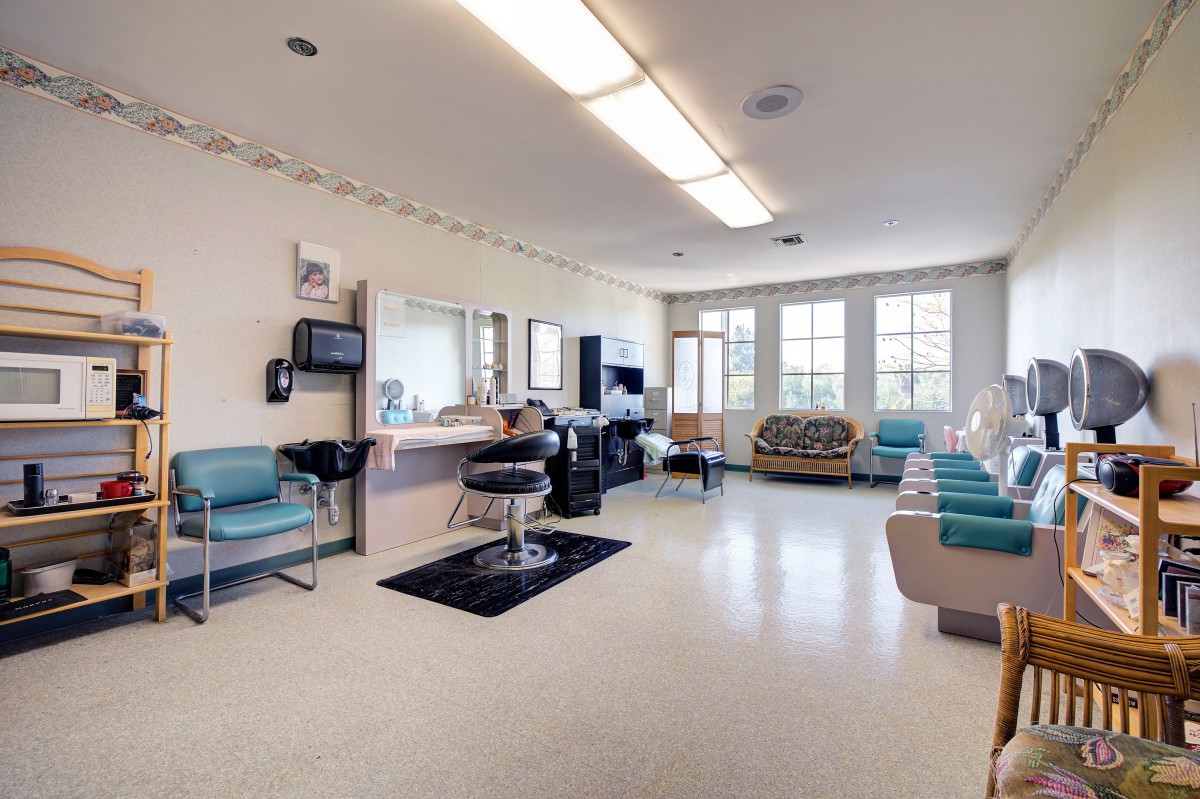 An interior view of a bright and spacious salon with multiple seating areas and hair styling stations.