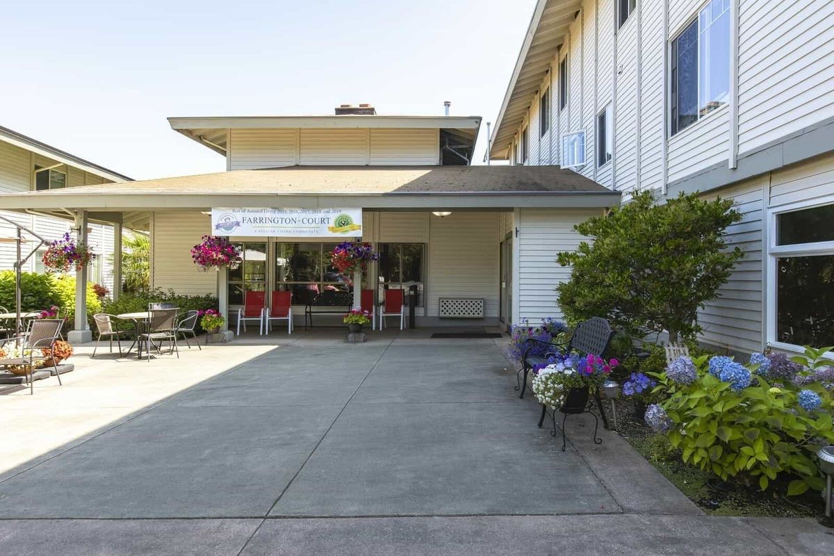 A building entrance adorned with flowers and a covered veranda.