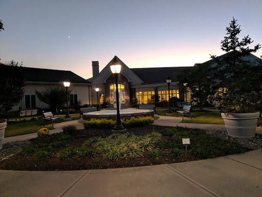 A serene evening view of a beautifully landscaped building surrounded by soft lighting.