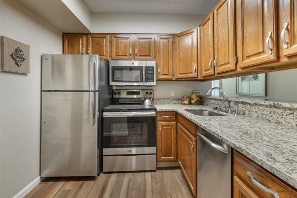A modern kitchen with stainless steel appliances and wooden cabinets.