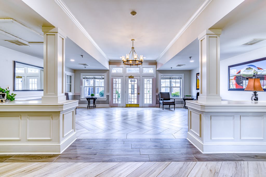 Spacious and luxurious living room with elegant columns and a central chandelier.