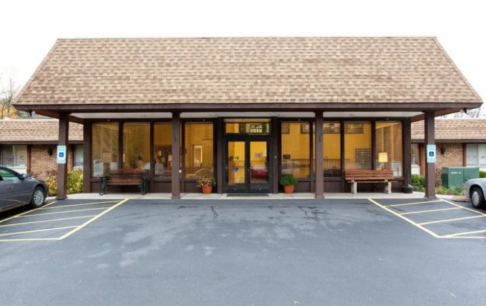 A storefront with large windows and an empty parking lot.