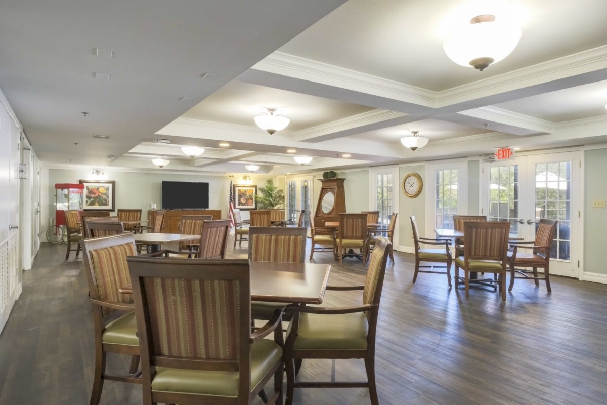 A well-lit dining area with wooden tables and chairs, featuring elegant interior decor.