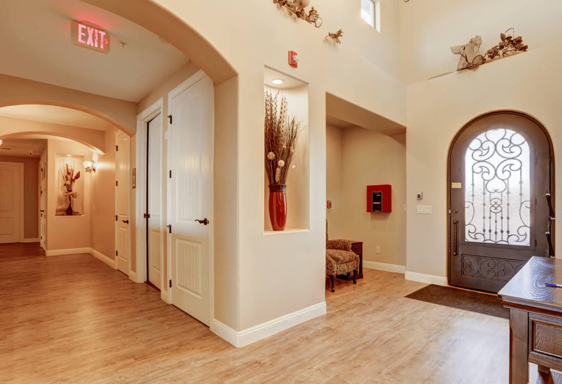 A modern hallway with elegant decor and artwork, leading to an entrance door.