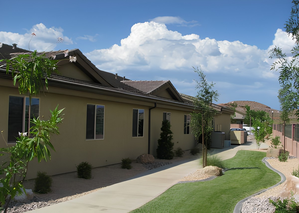 A suburban house with a well-maintained yard and clear skies.