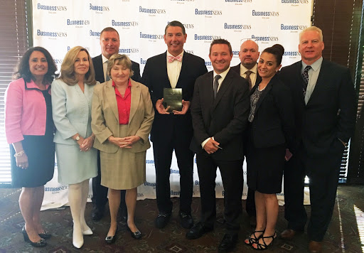 A group of professionals gathered for an award ceremony, celebrating achievements in their field.