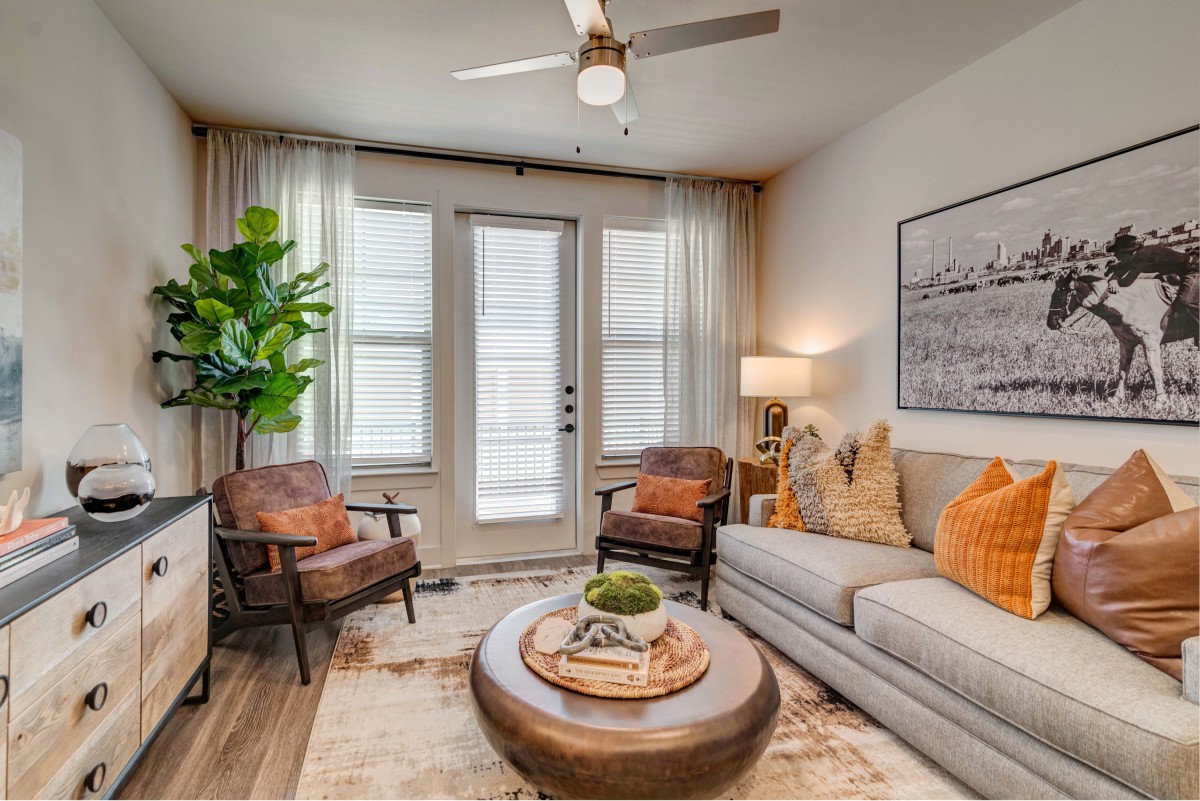 A cozy and modern living room featuring a comfortable sofa, stylish chairs, a round coffee table, and indoor plants.