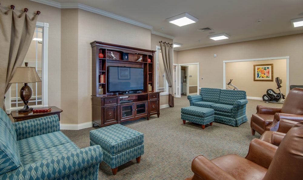 A cozy living room with a television and comfortable seating arrangements.